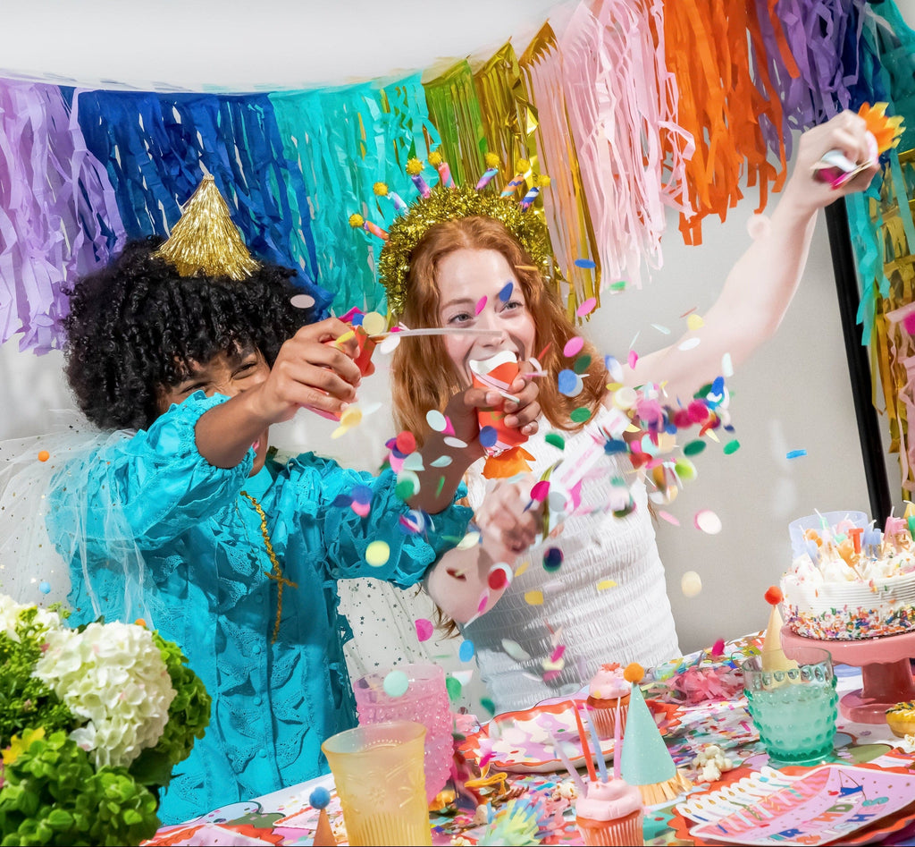 Birthday party cracker set with confetti and candle toppers, crackers held at birthday table