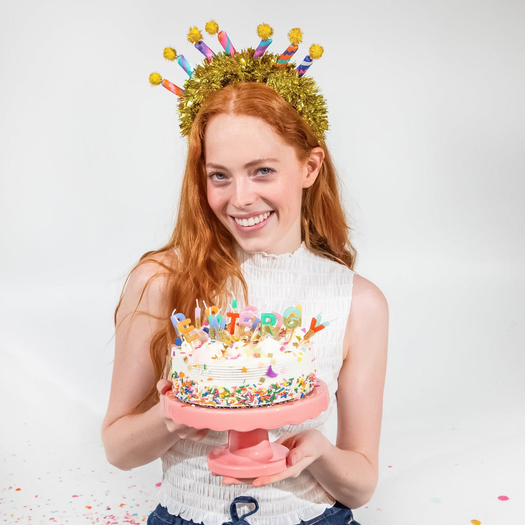Gold tinsel headband featuring colorful candle novelty tips and yellow pom-pom details