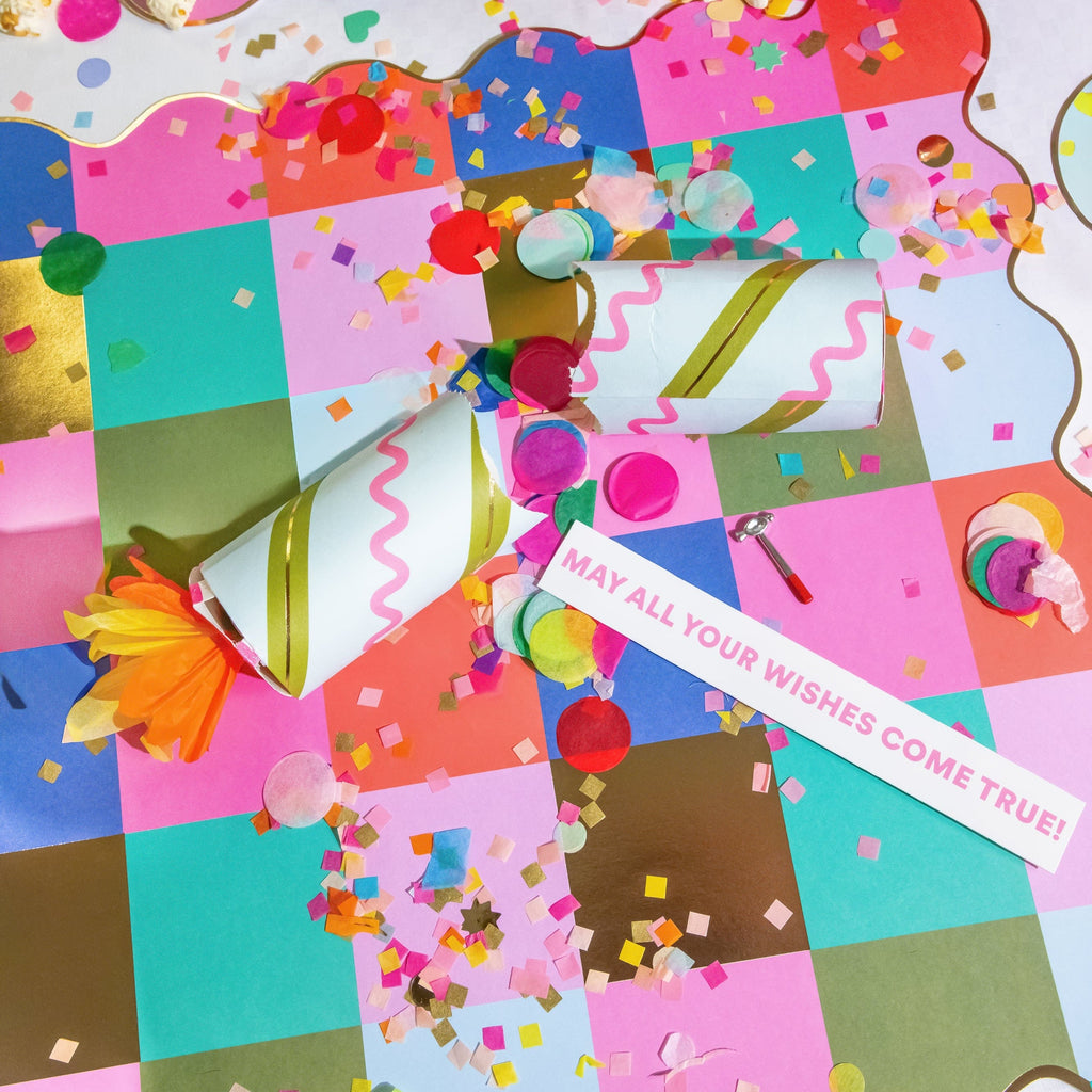 Birthday crackers amid colorful confetti and paper streamers, striped tube bodies
