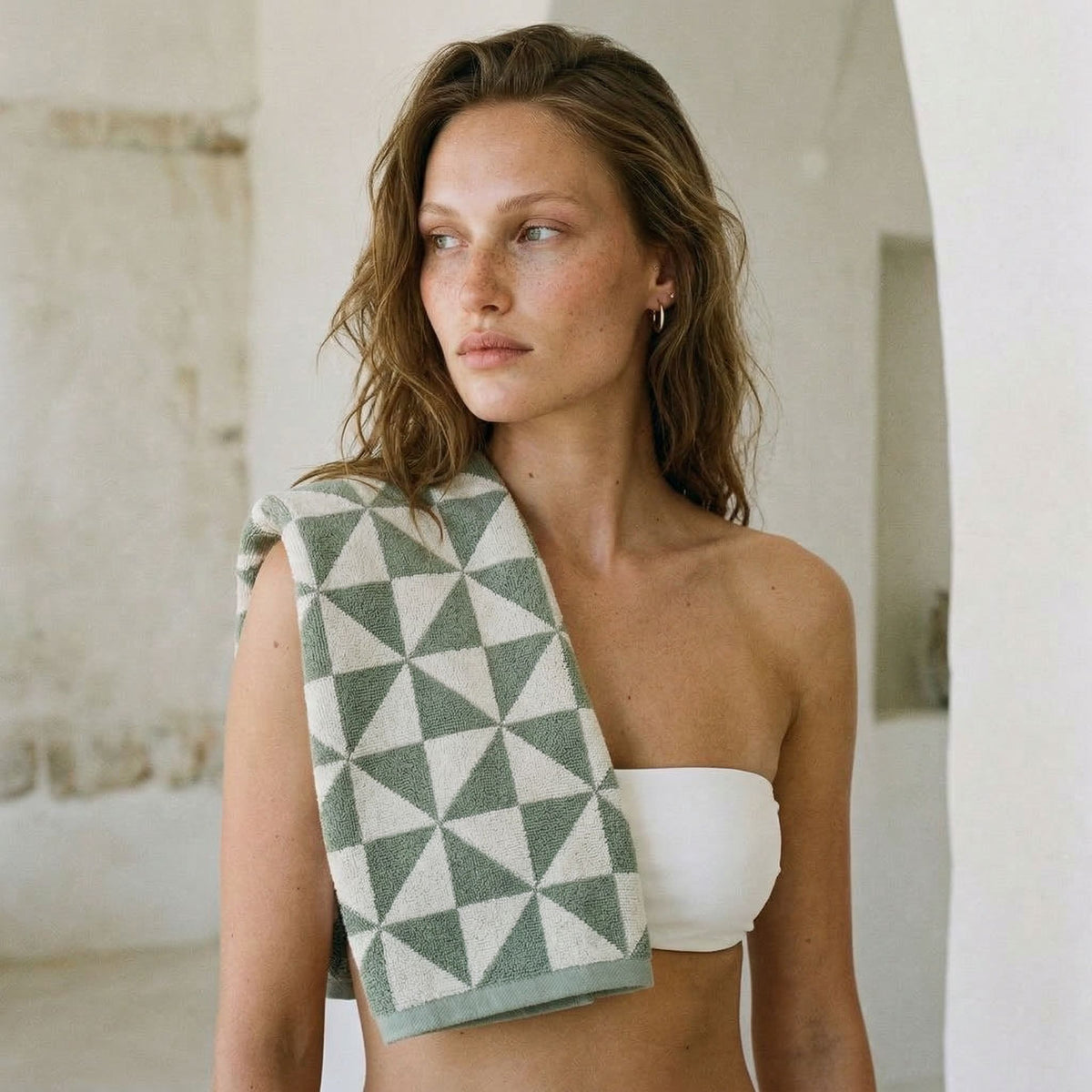 Australian cotton towels, green geometric triangle pattern towel draped over the shoulder