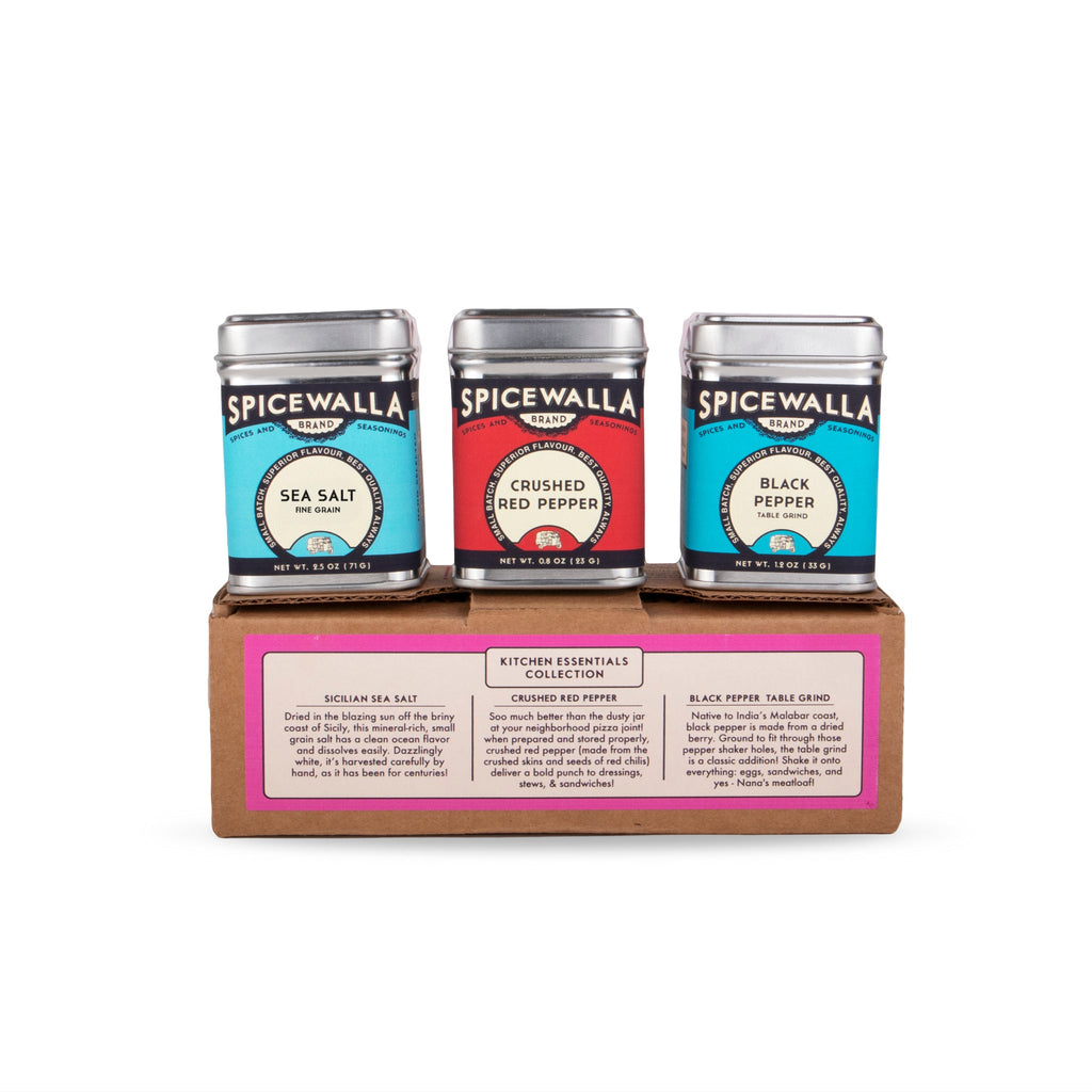 Three Spicewalla spice tins on a wooden tray: sea salt, crushed red pepper, black pepper
