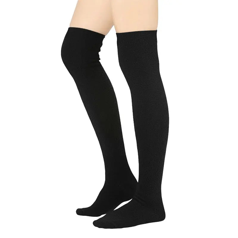 Over-the-knee fleece socks in black knit, worn and showing the foot area.