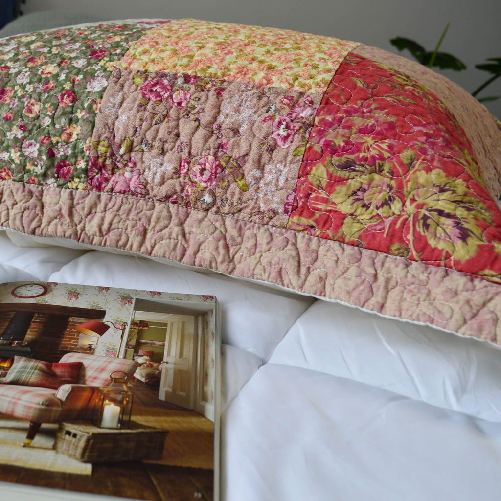 Quilted patchwork floral pillow sham with ruffled edge, yellow, pink, and red panels