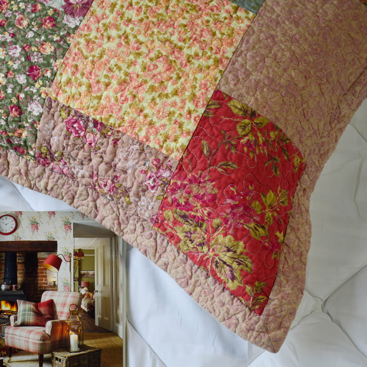 Patchwork floral pillow sham with quilted border and mixed yellow, red, and brown blocks
