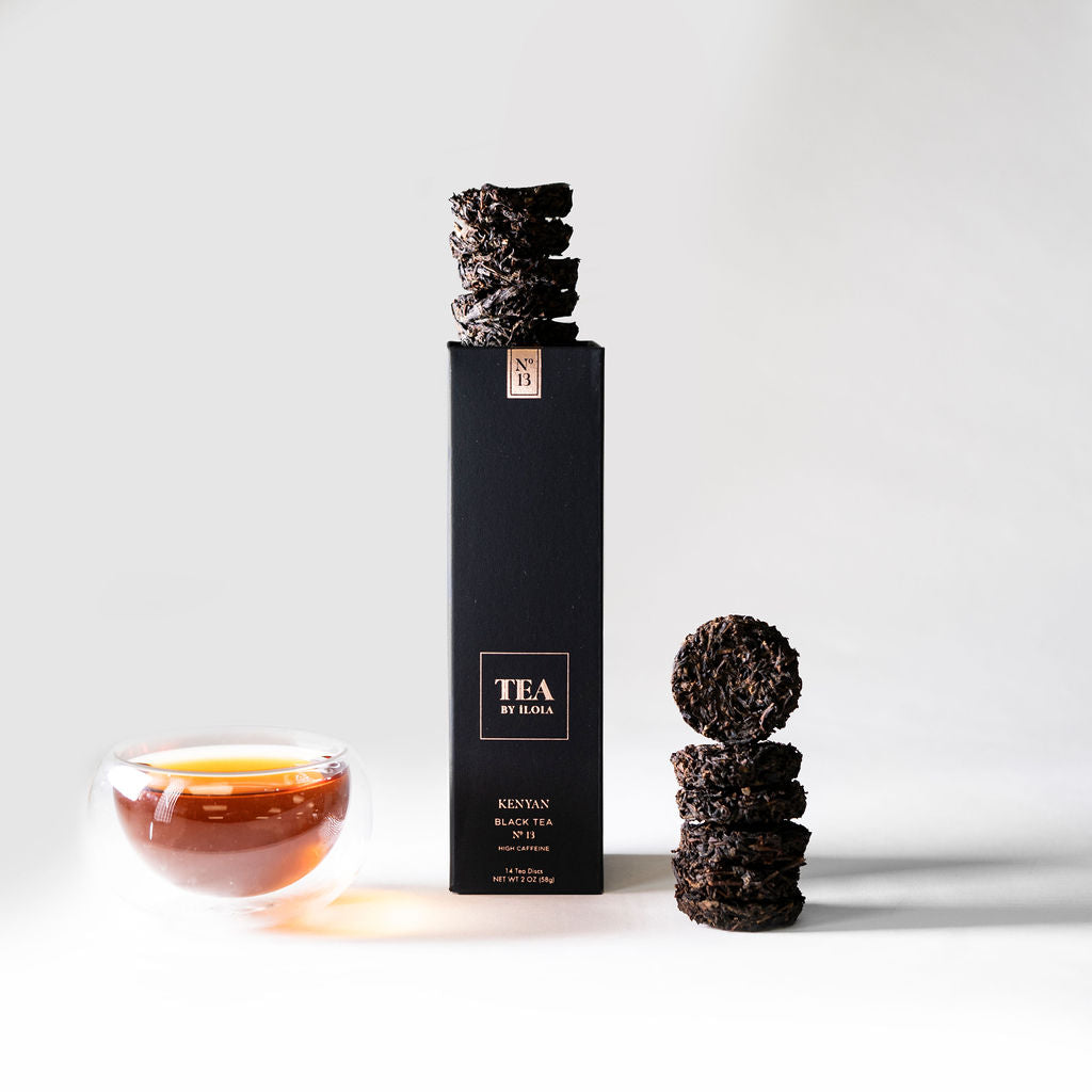 Kenyan No. 13 black tea box with pressed tea discs and a cup of brewed tea