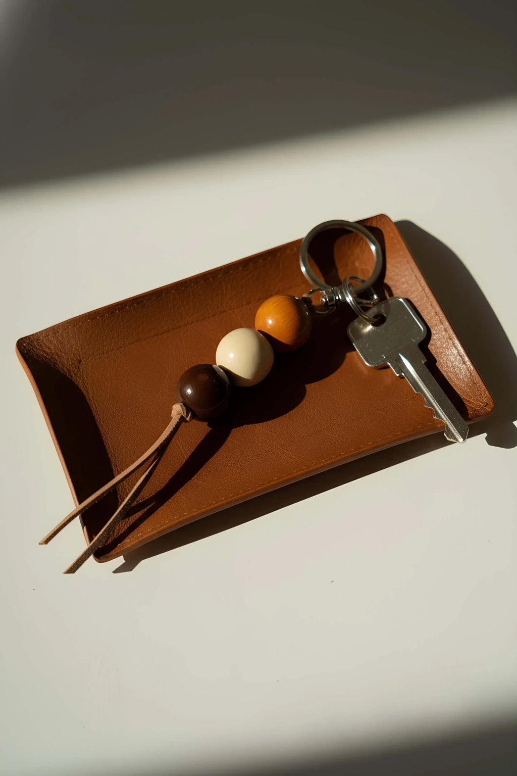 Handmade ceramic keychain on a brown card with metal keyring and bead tassels