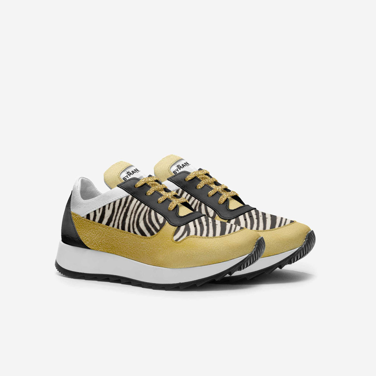 Kids' zebra-and-gold vegan sneakers with black lace trim and chunky white midsole.
