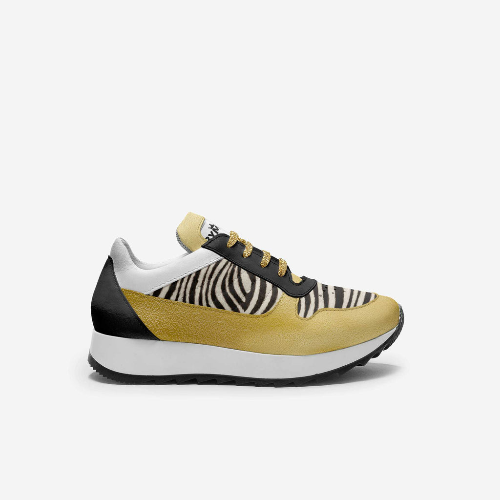 Kids' animal-print vegan sneakers with gold glitter laces, black accents, white sole.