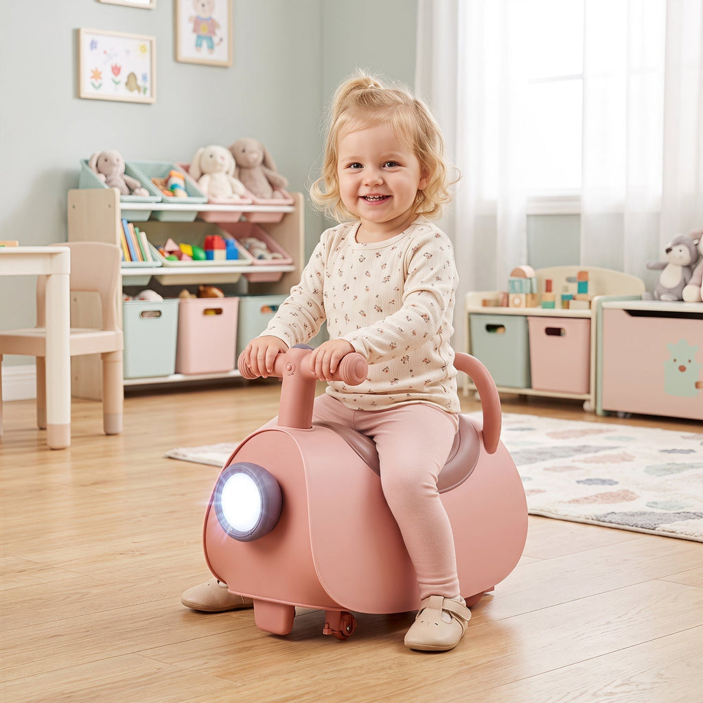 Pink kids push ride-on car with glowing headlight and front handle, child seated