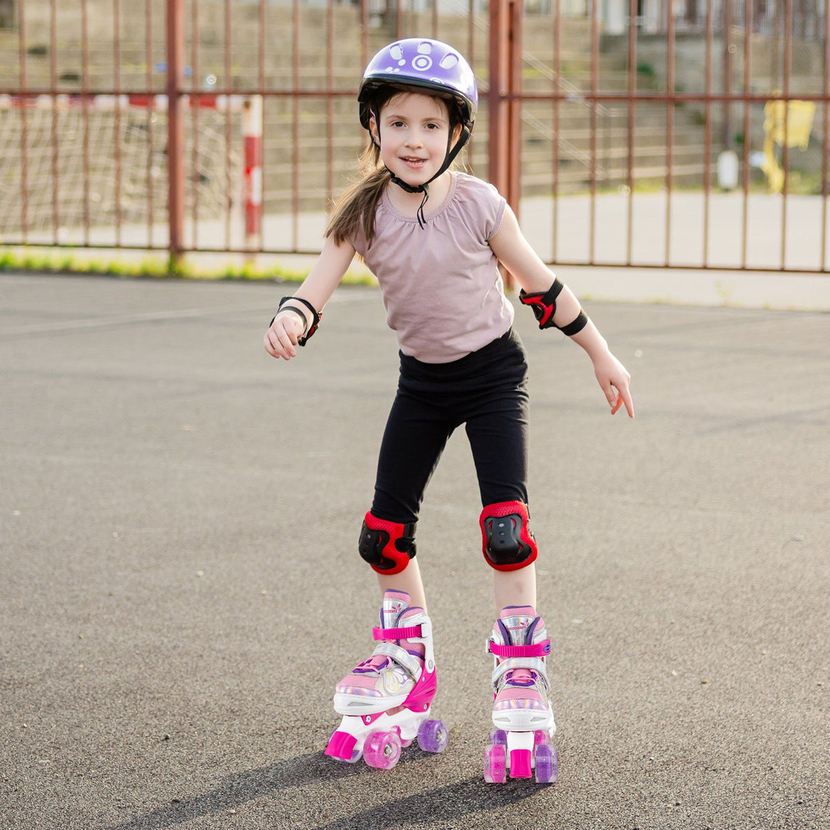Kids adjustable quad roller skates in pink with light-up wheels and black toe guards