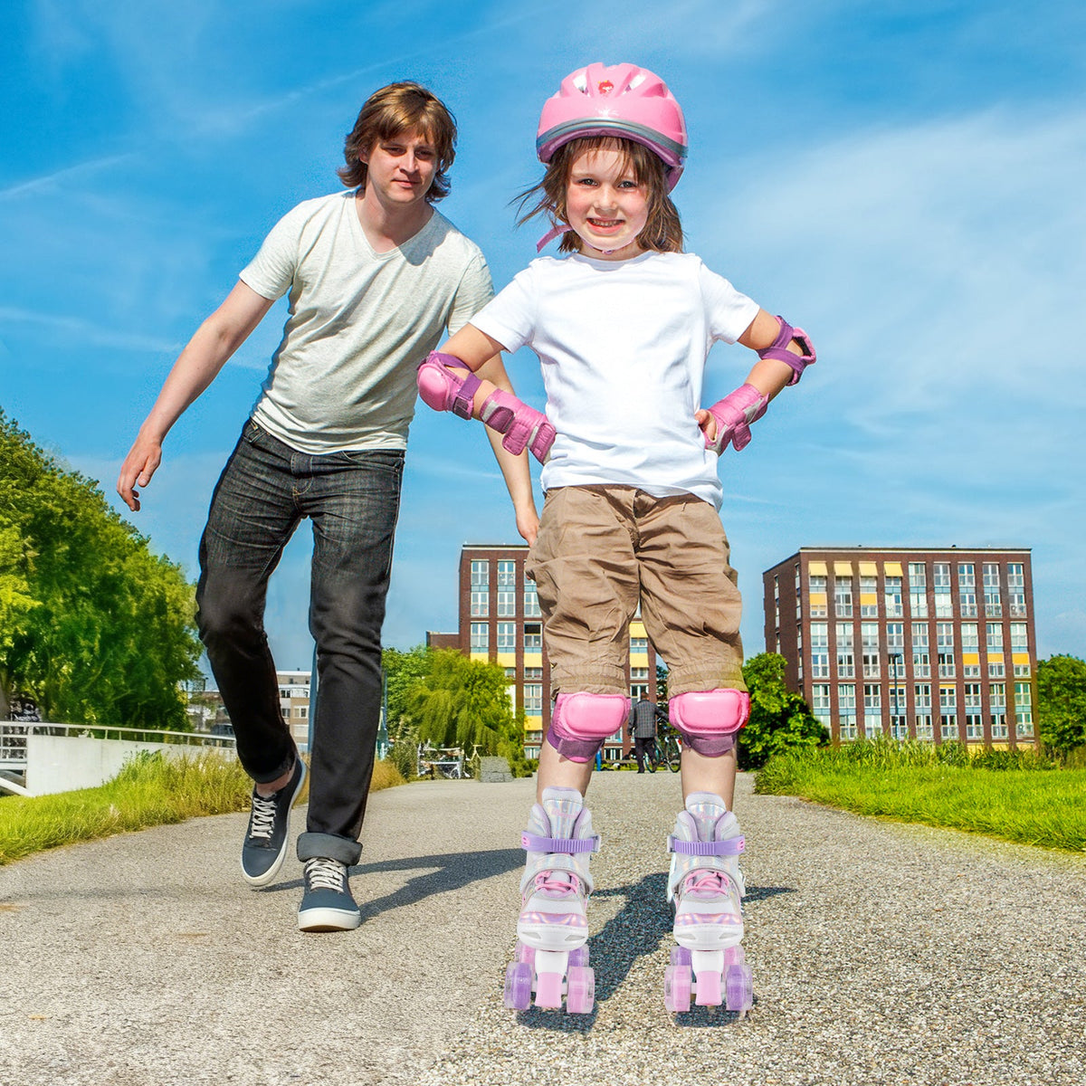 Kids pink quad roller skates with light-up wheels, front view on child's feet
