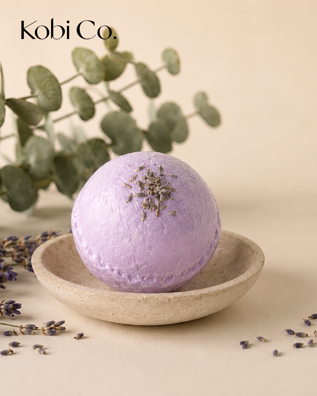 Purple bath bomb with lavender buds on a shallow stone dish
