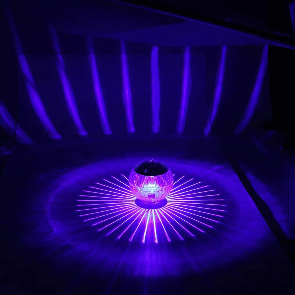 Solar LED floating dome lamp casting bright purple light starburst