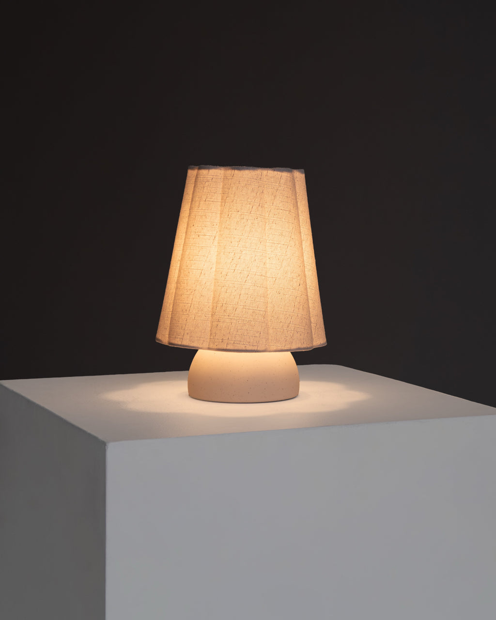 Kylie table lamp with amber-lit textured drum shade and white base