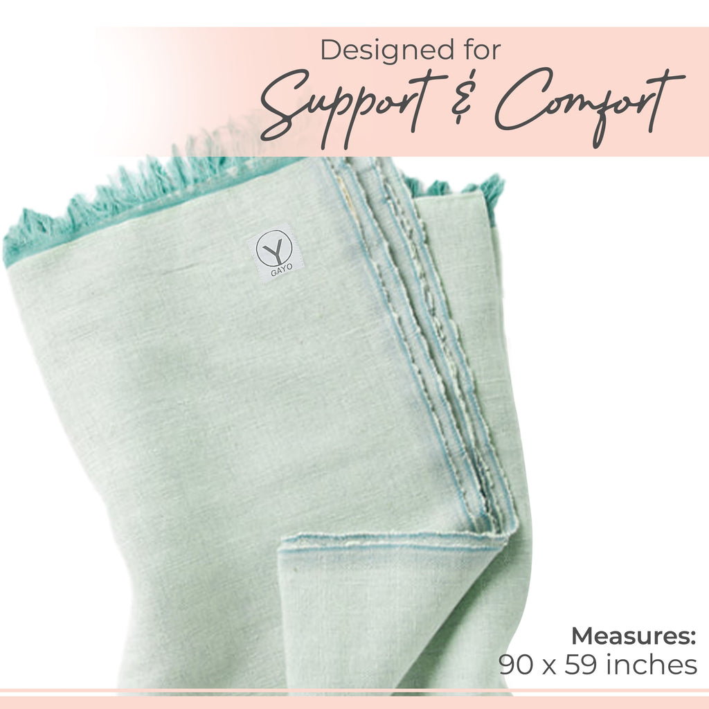 Light sage yoga blanket corner with stitched edge, tassel fringe, and small logo patch.