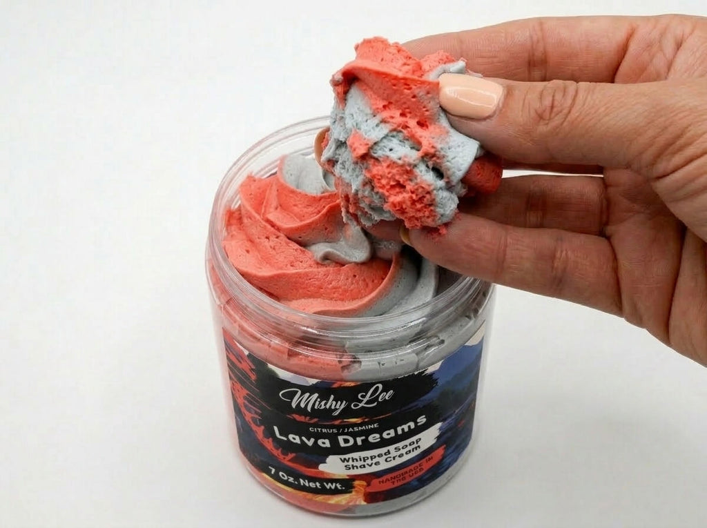 Hand scooping red and gray whipped soap and shave cream from jar