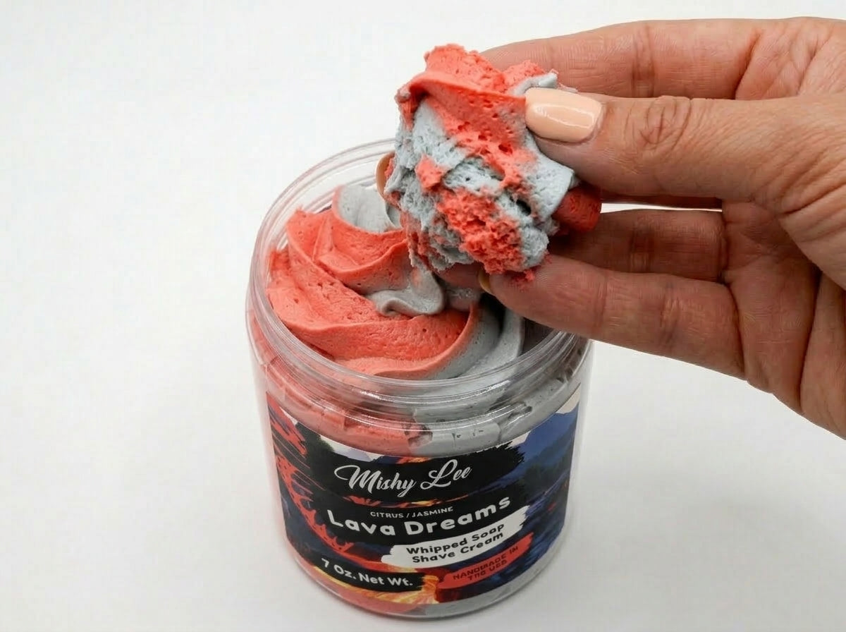 Hand scooping red and gray whipped soap and shave cream from jar