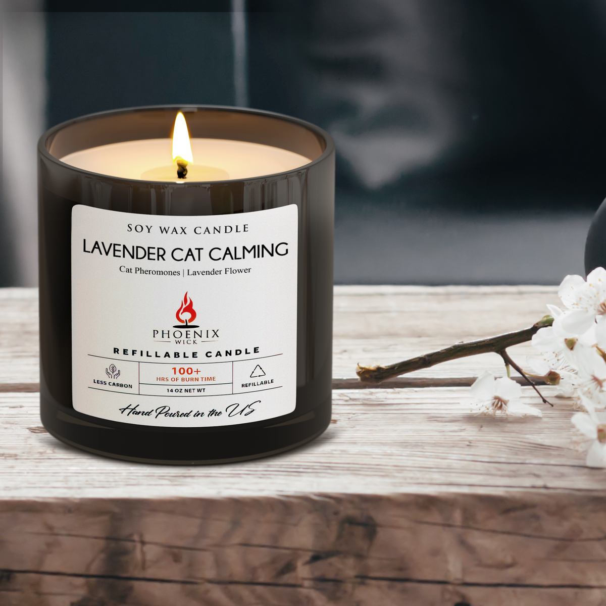 Lavender cat calming refillable candle in black jar, label visible with flame