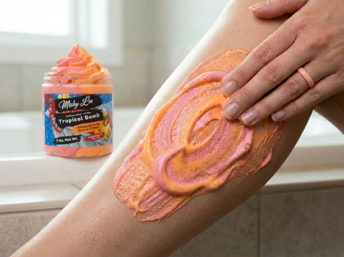 Hands applying a pink-orange whipped soap swirl to skin