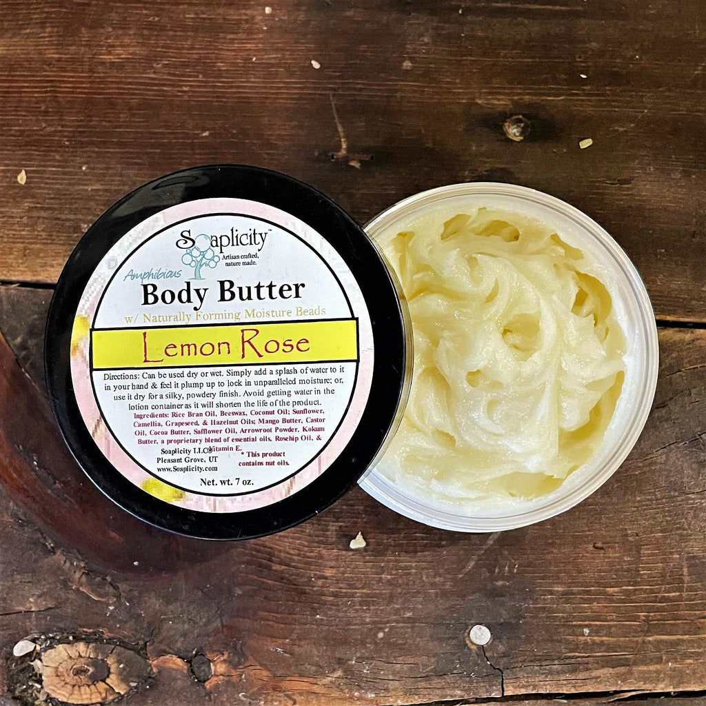 Body butter jar open with pale-yellow cream butter in tub, lid to the side