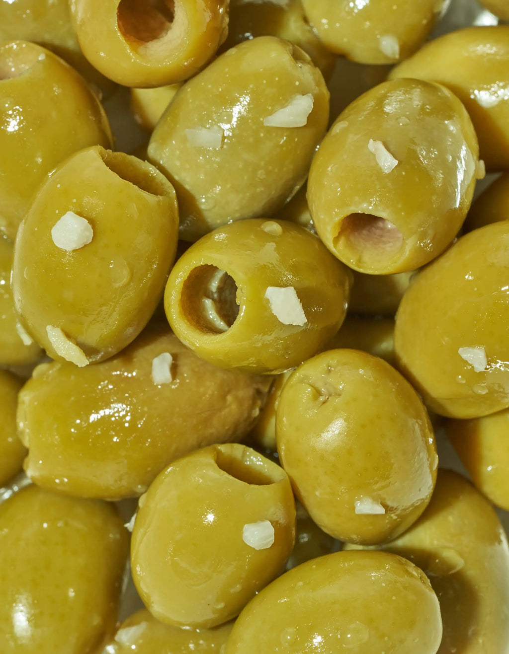 Close-up of yellow-green lemon garlic green olives in a bowl