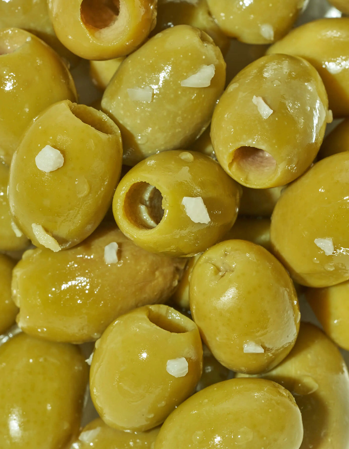 Close-up of yellow-green lemon garlic green olives in a bowl