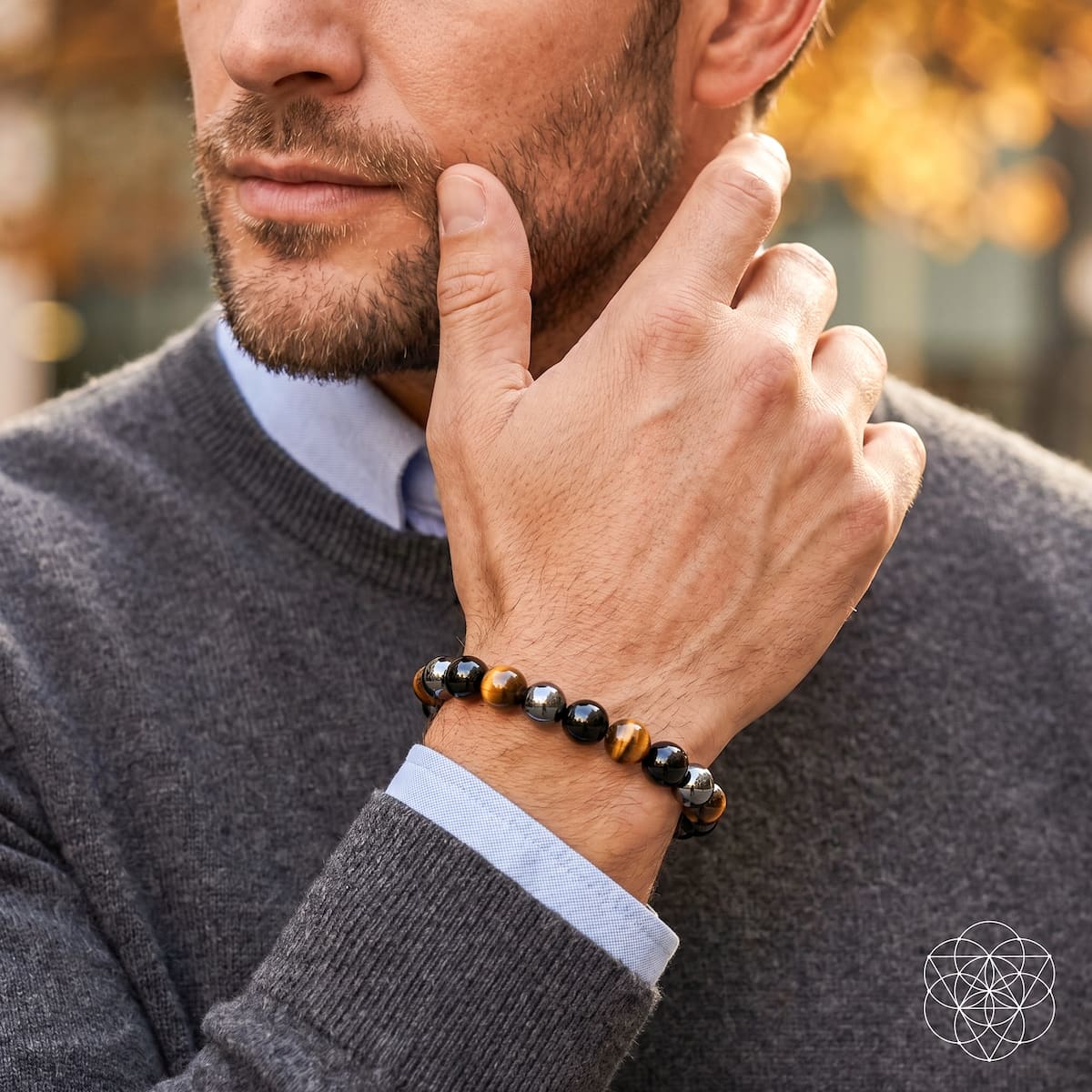 Beaded stretch bracelet on wrist; black round stones with tiger-eye beads and hematite highlights.