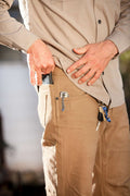 Coyote tan pants with front button closure and hand-access pocket opening