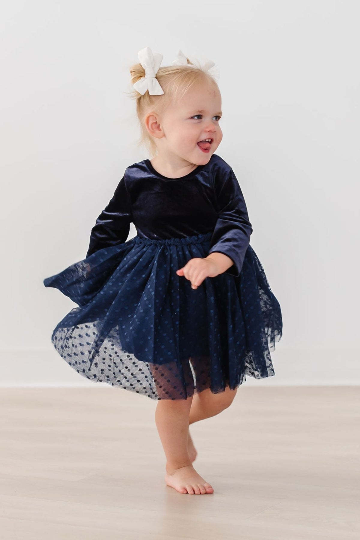 Navy velvet long-sleeve tutu dress with bow detail and dotted tulle hem