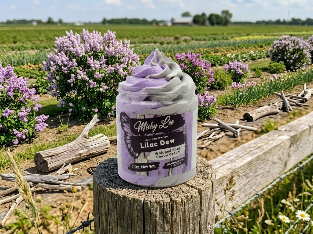 Whipped soap and shave cream jar sitting on a wooden stump in a field of flowers