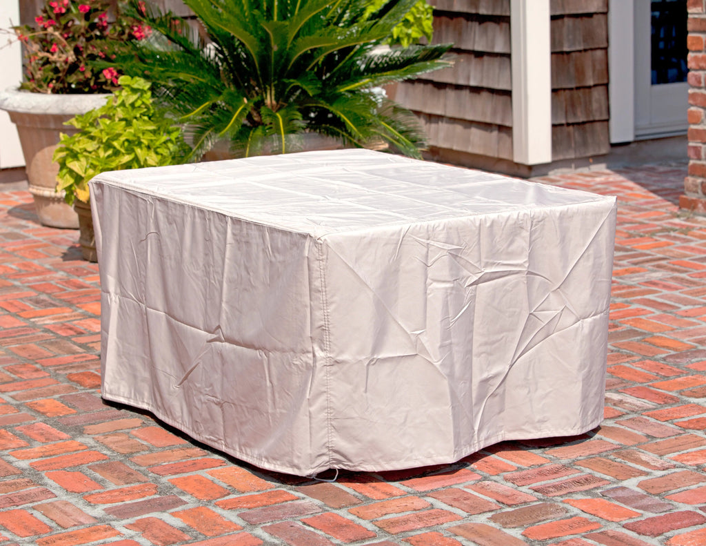 Rectangular gas fire pit table with fitted white protective cover, corner view