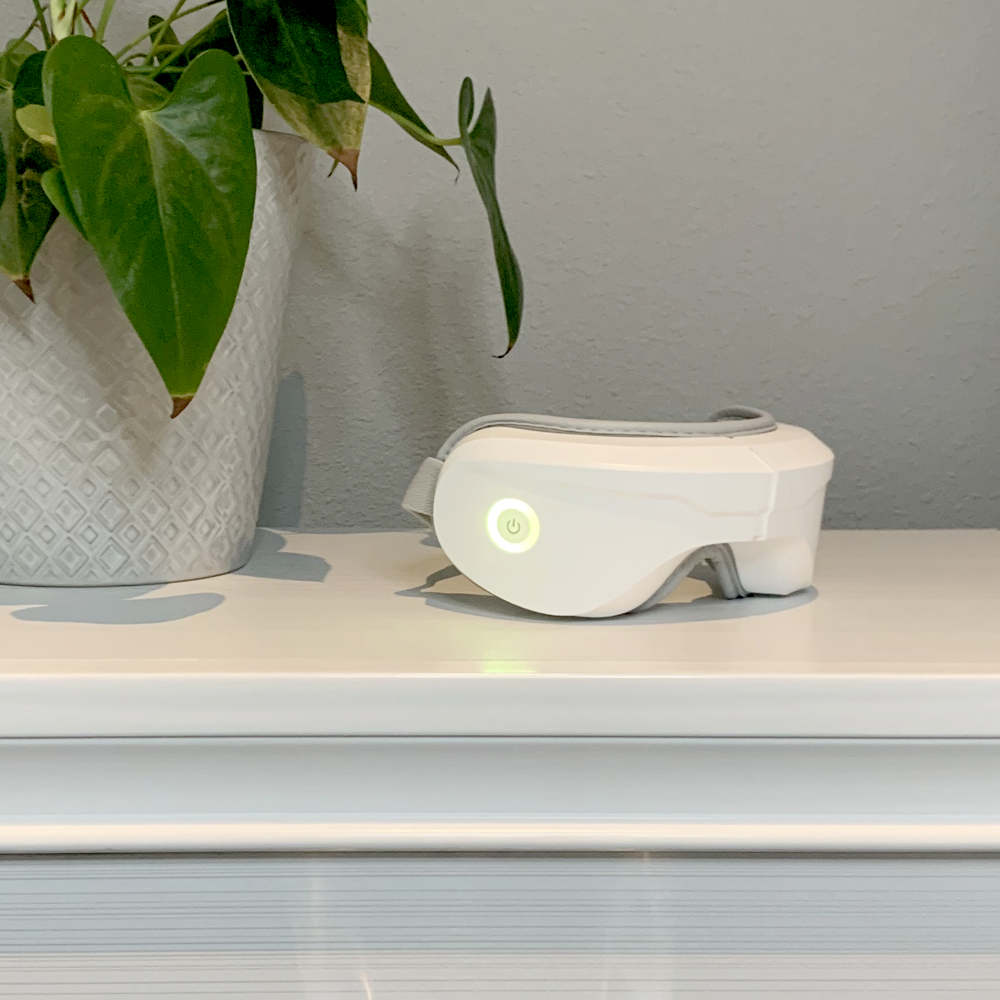 White heated eye massager with glowing power button