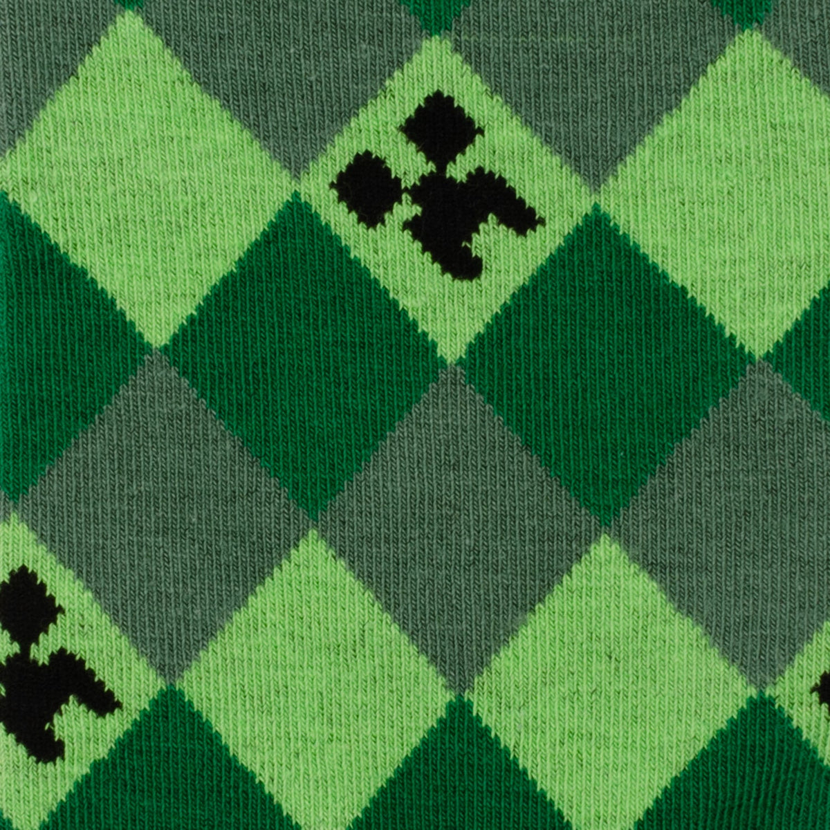 Close-up of Minecraft Creeper sock fabric: green diamond argyle with black pixel icons