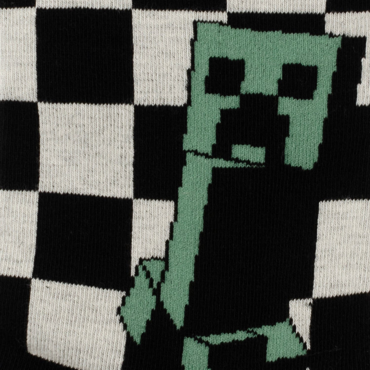 Close-up of Minecraft Creeper socks: black/white check with green Creeper graphic