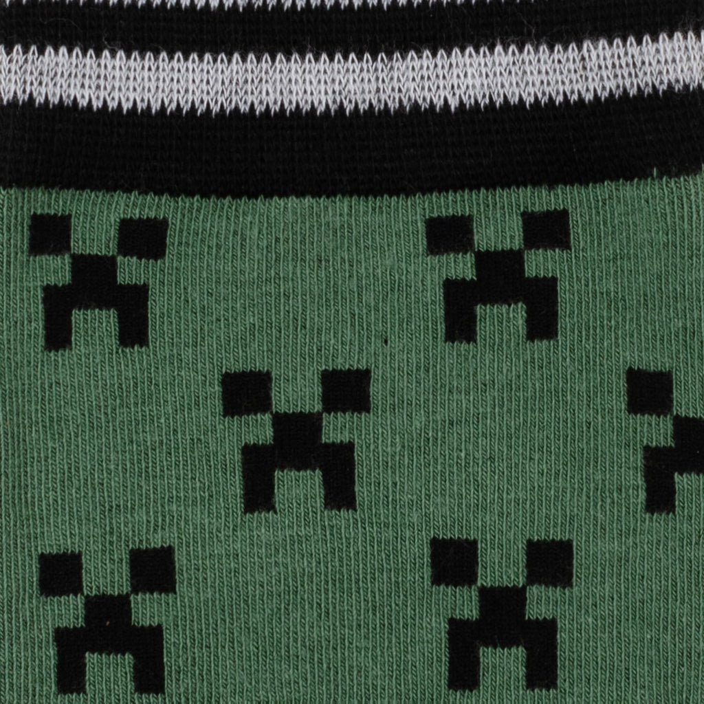 Close-up of Minecraft Creeper socks: green fabric with repeating black pixel icons