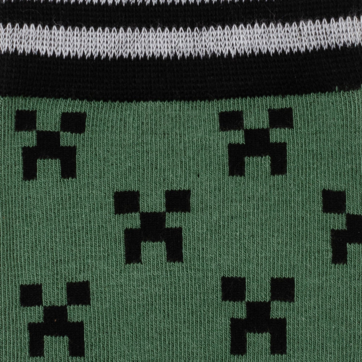 Close-up of Minecraft Creeper socks: green fabric with repeating black pixel icons