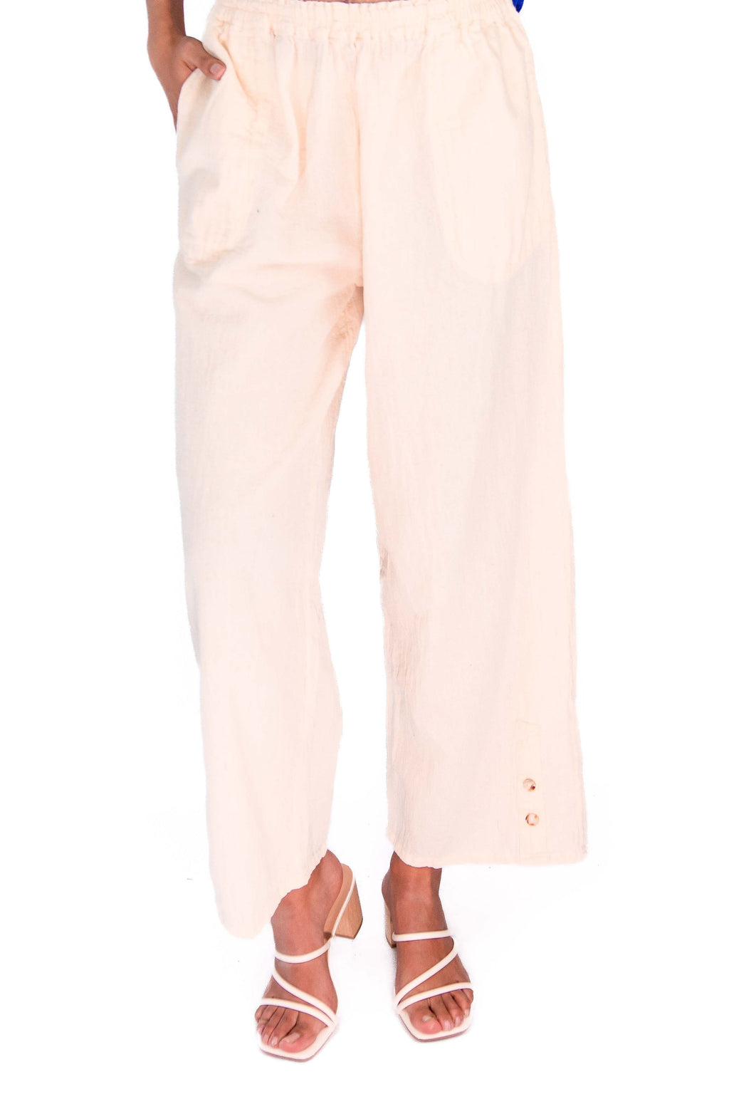 Blush pink cotton gauze pants with elastic waist, relaxed wide leg, ankle length, button detail at hem