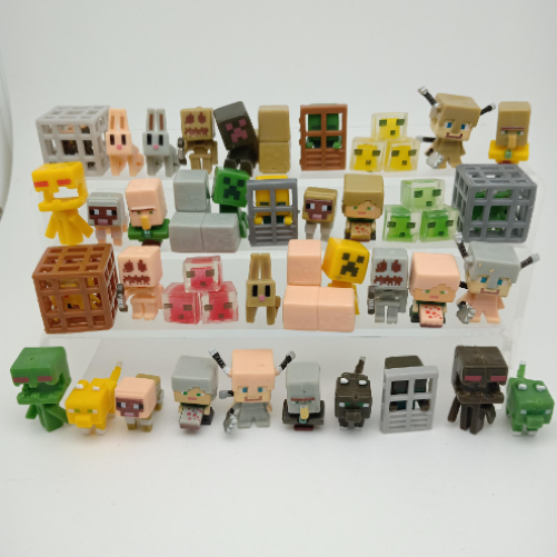 Assorted Minecraft-style toy figures and block accessories in a mixed pile