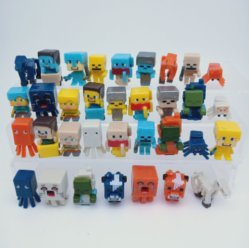 Assorted Minecraft-style toy characters and block accessories in a mixed pile