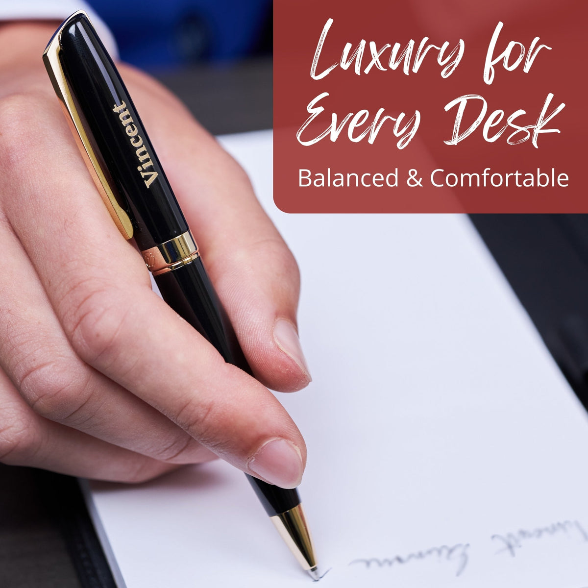 Glossy black rollerball pen with gold tip and clip, held in a hand