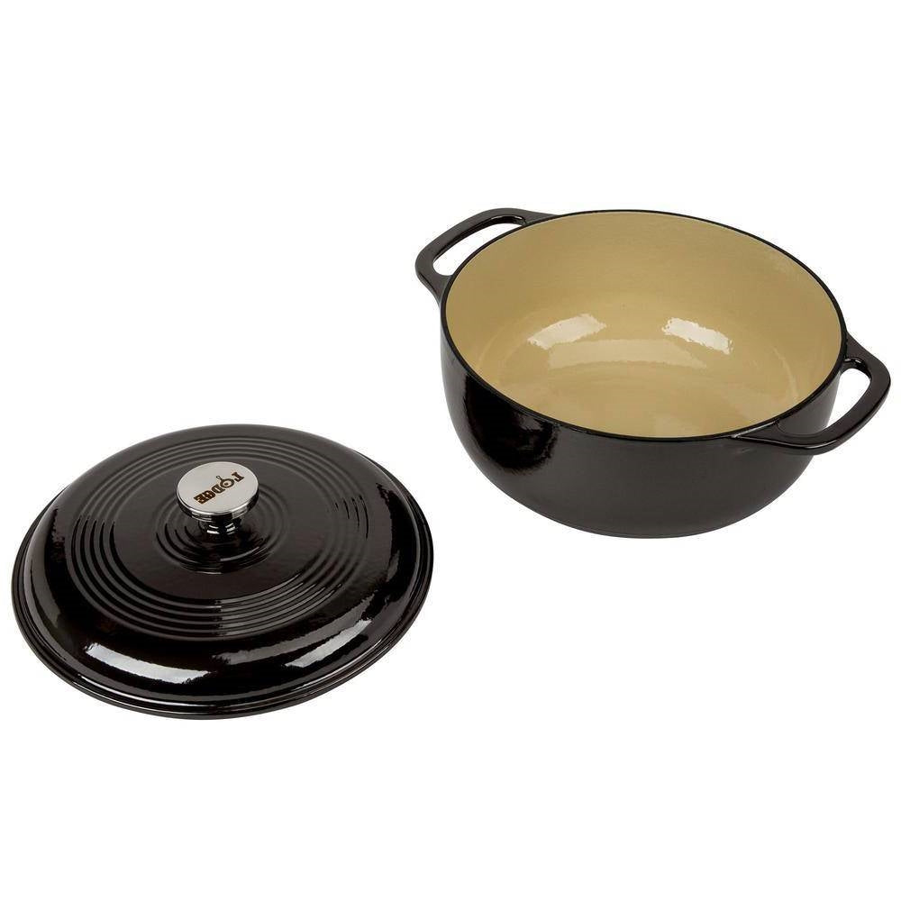 Black enamel Dutch oven with lid and lid nearby, loop side handles