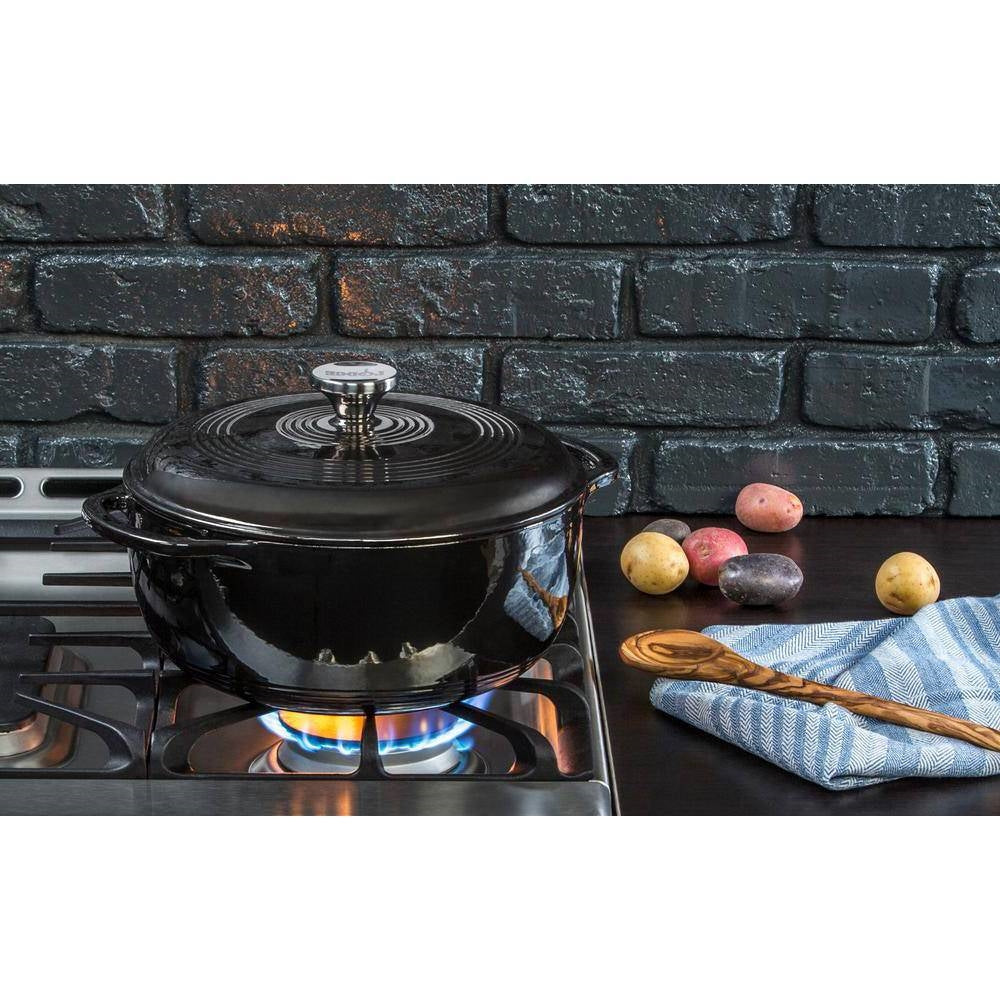 Black enamel round Dutch oven with lid and side handles on stovetop