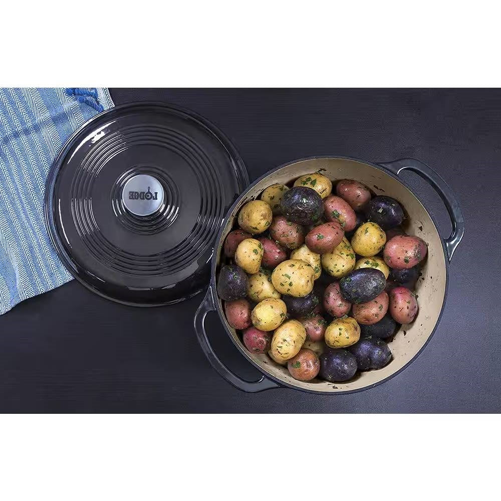 Black enamel Dutch oven with lid off, potatoes inside, side handles