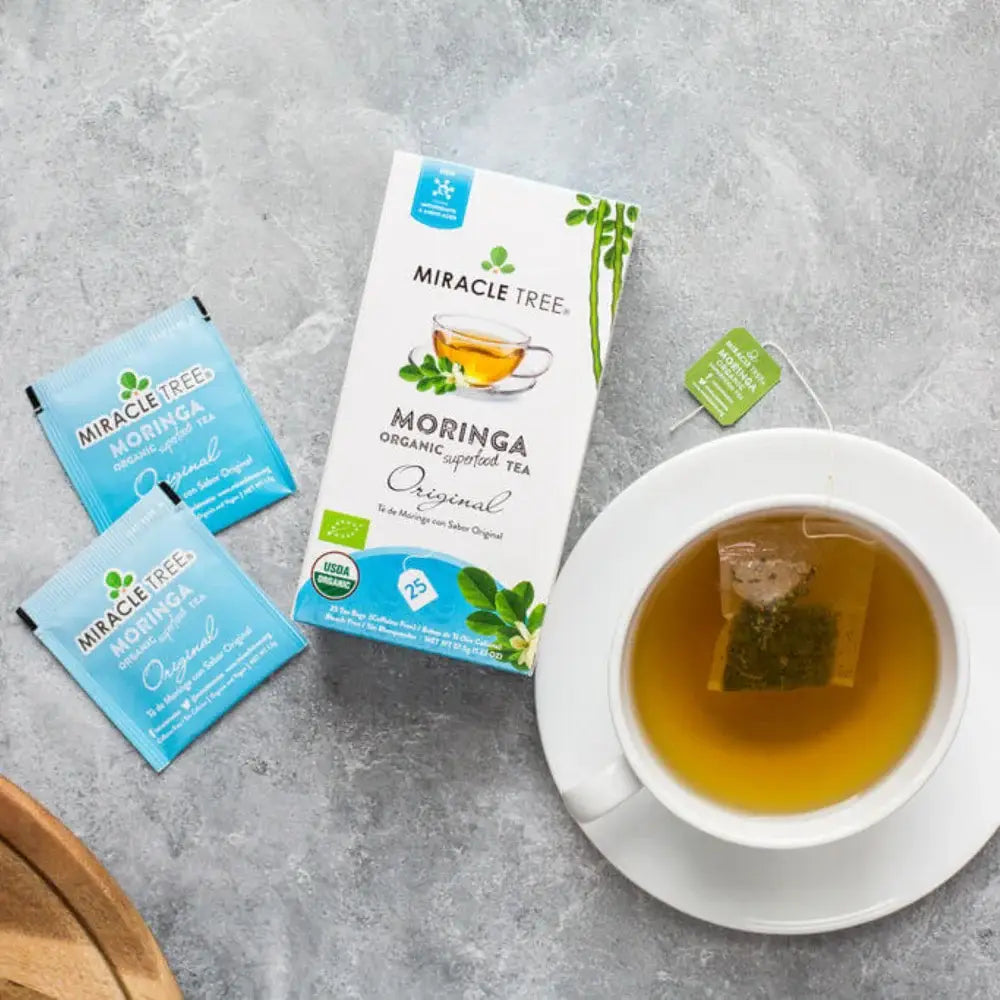 Moringa original tea sachets with a cup of amber herbal tea