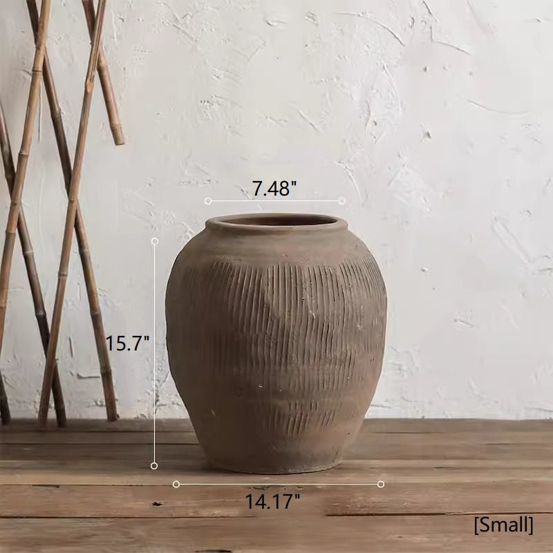 Small round brown earthenware pot with vertical ribbed pattern and wide mouth