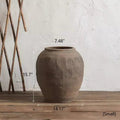 Small round brown earthenware pot with vertical ribbed pattern and wide mouth