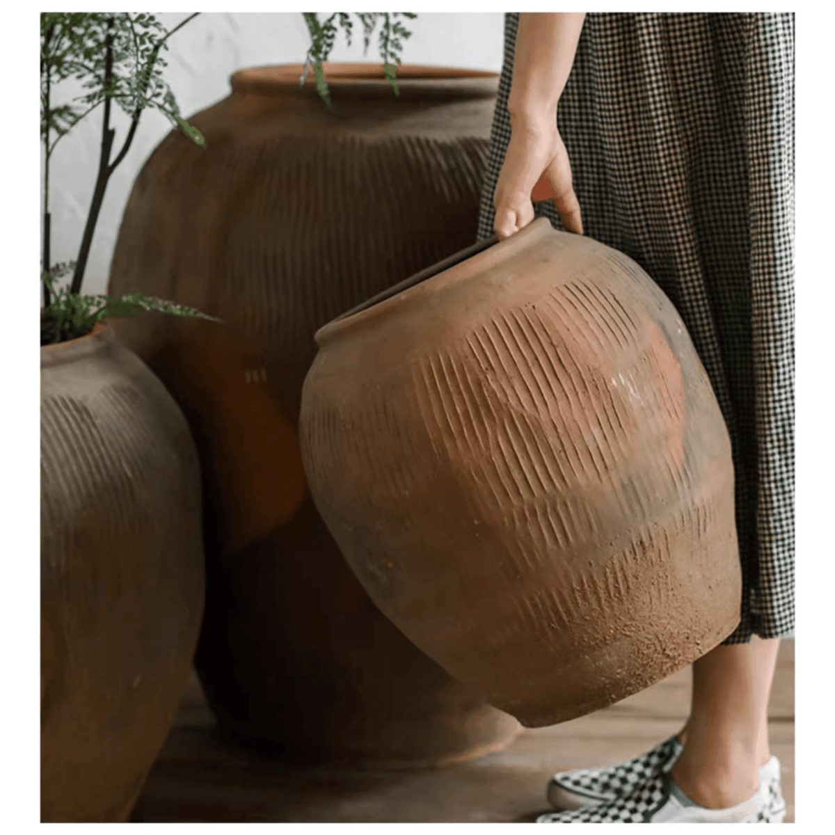 Brown ribbed earthenware pot with wide mouth opening in hand