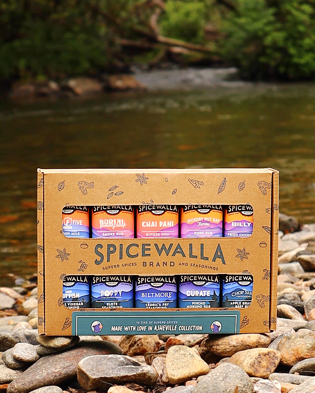 Spicewalla 10-pack spice gift box on rocks with visible labeled seasoning canisters