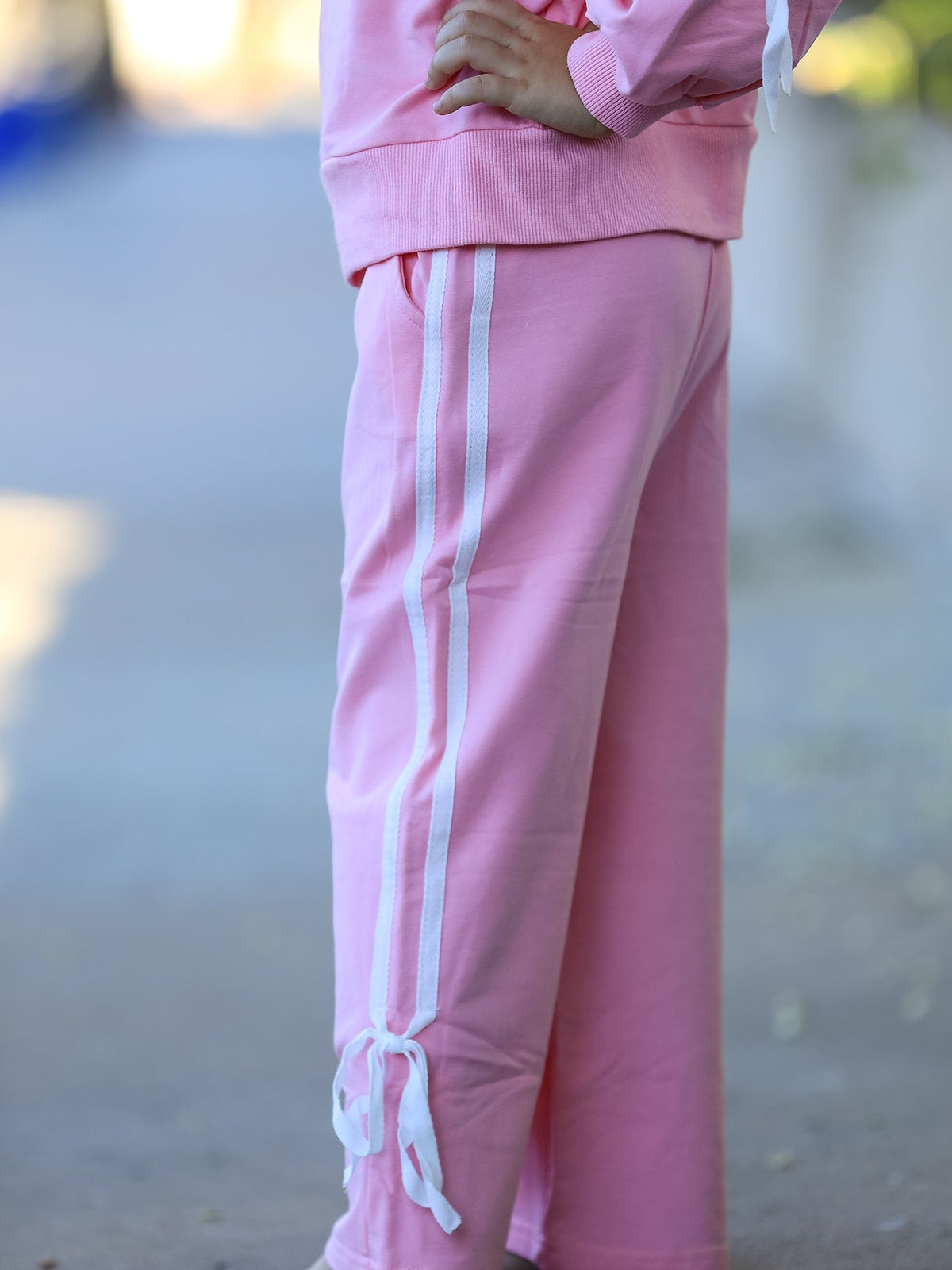 Girls pink pants with side stripe and white tassel bow ties at hem