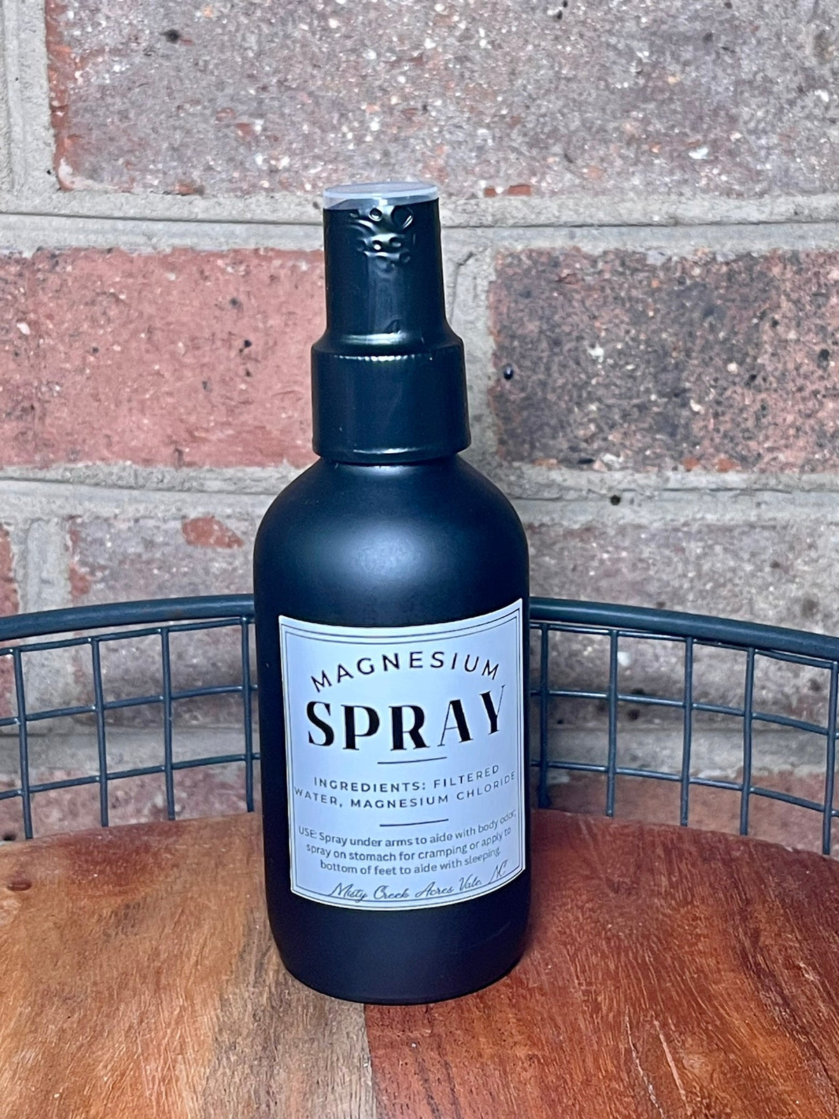 Magnesium spray bottle with mist pump and label on wooden tabletop